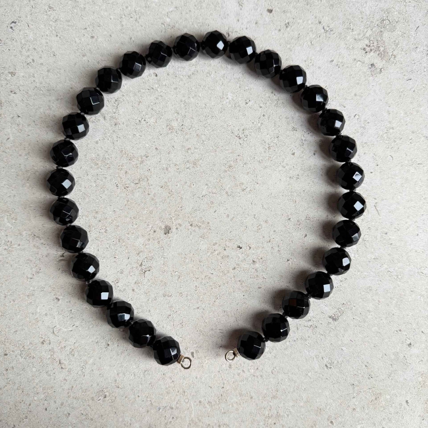 Ketting van grote onyx facetkralen met gold filled open einden