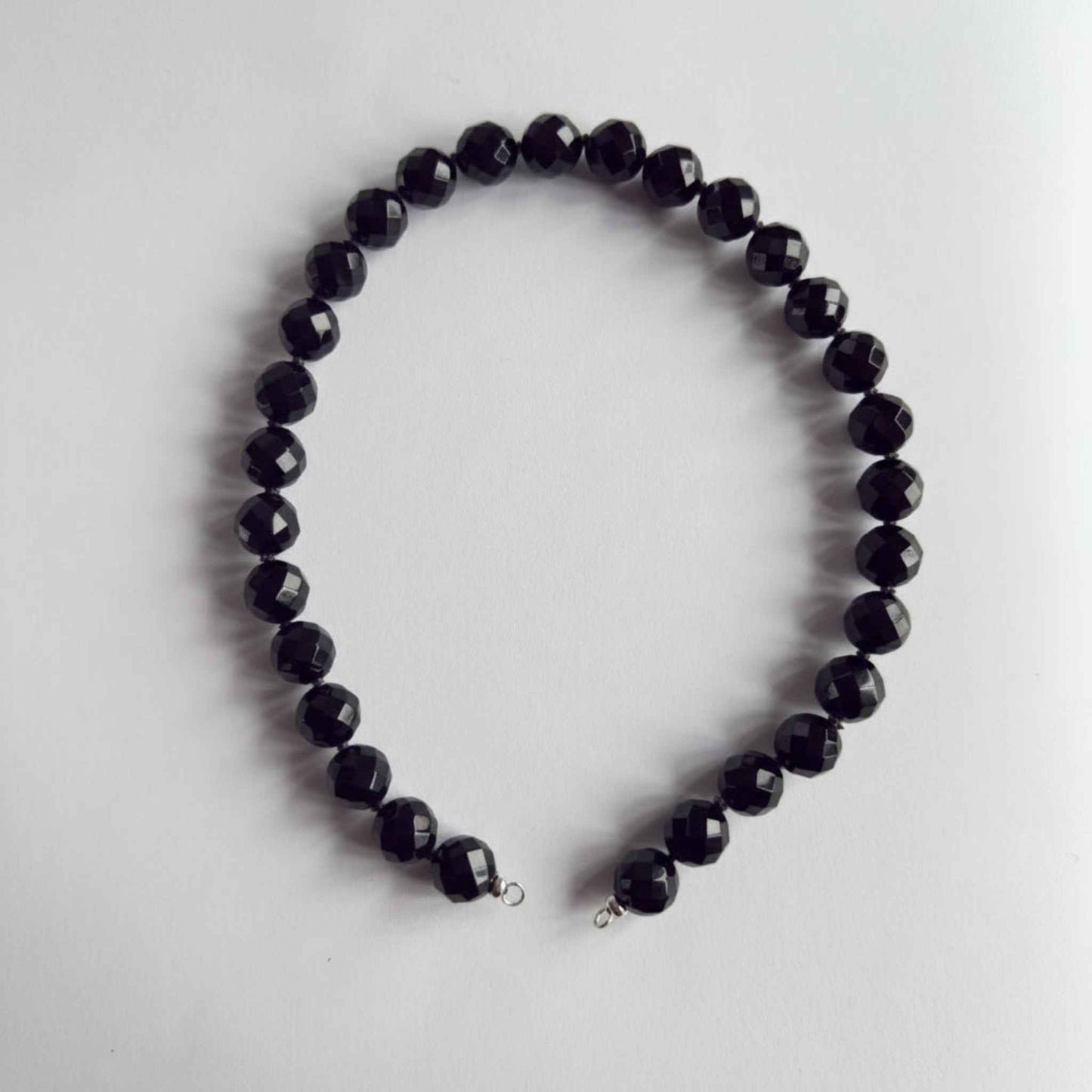 Ketting van grote onyx facetkralen met zilveren open einden