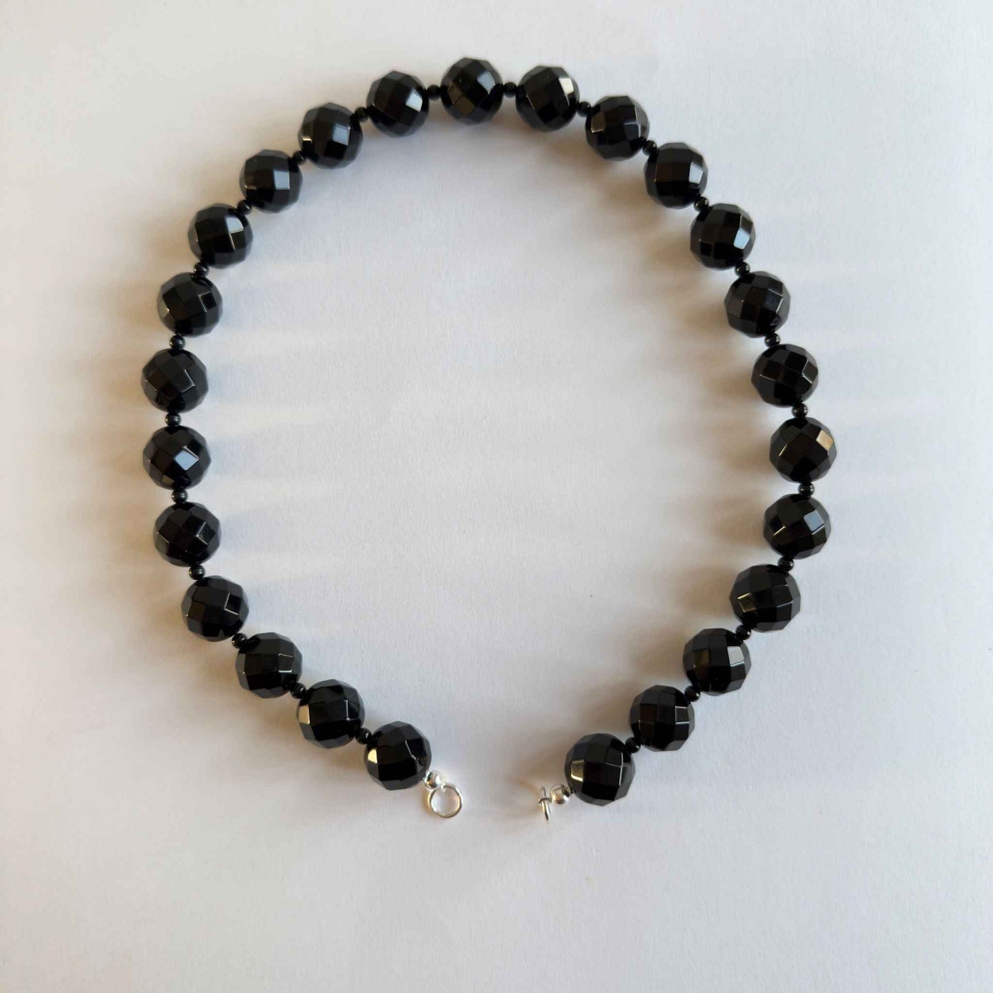Ketting van grote onyx kralen met zilveren uiteinden