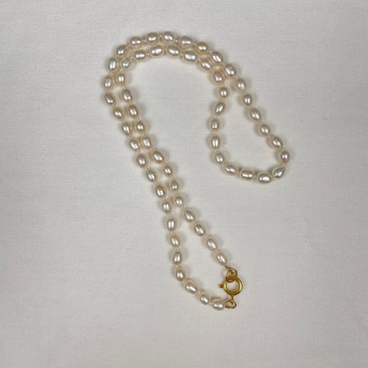 De zoetwaterpareltjes zijn geknoopt op een dubbele zijden draad. De parels hebben een rijstkorrelvorm en zijn 5 tot 6 mm lang. De ketting sluit met een decoratief gold filled veerslotje.