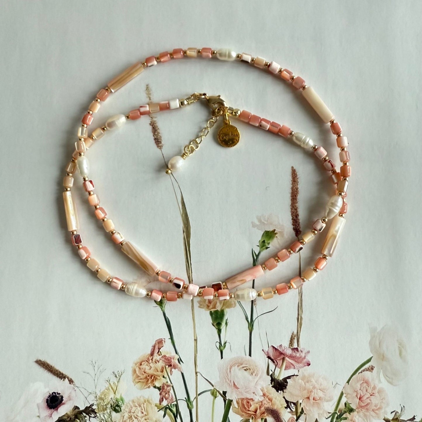 Ketting van roze schelpkralen en zoetwaterparels