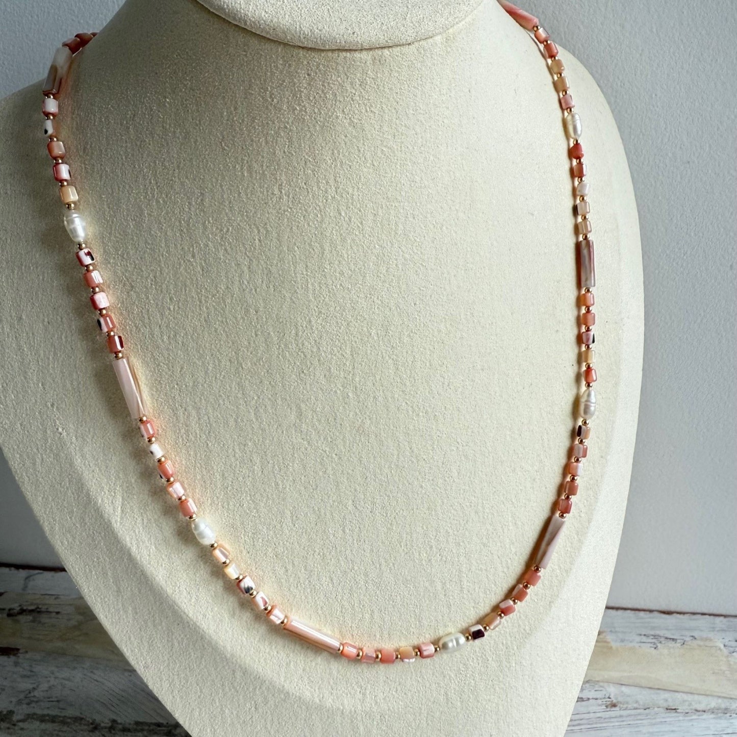 Ketting van roze schelpkralen en zoetwaterparels