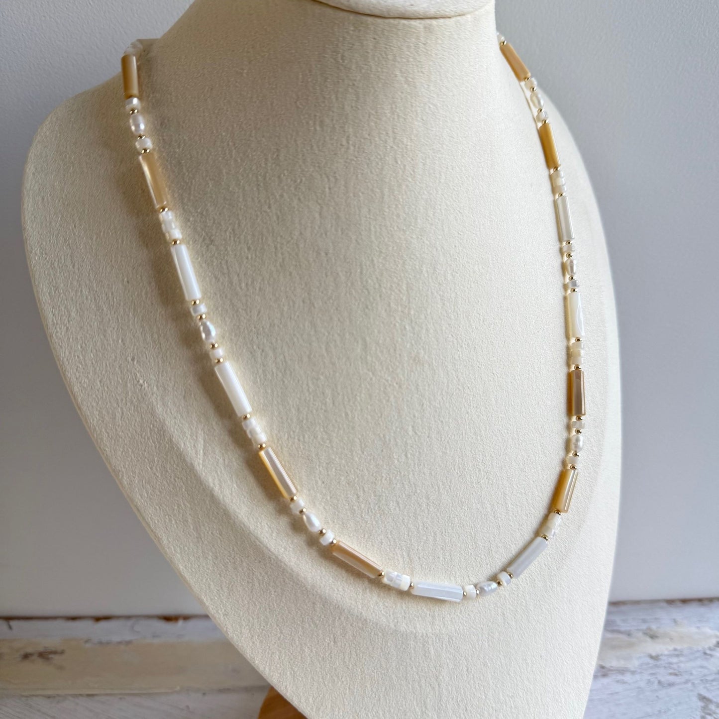 Ketting van witte schelpkralen en zoetwaterparels