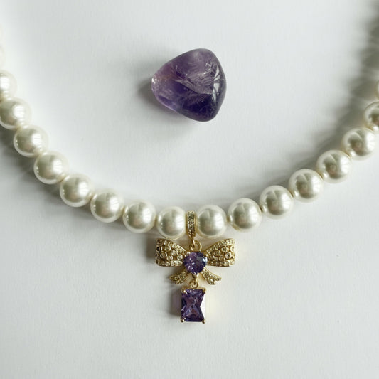 Ketting van schelpparels met paars strikje