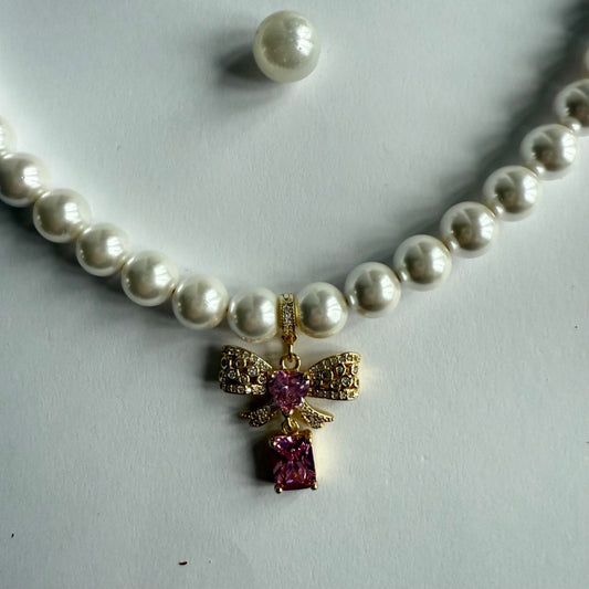 Ketting van schelpparels met roze strikje