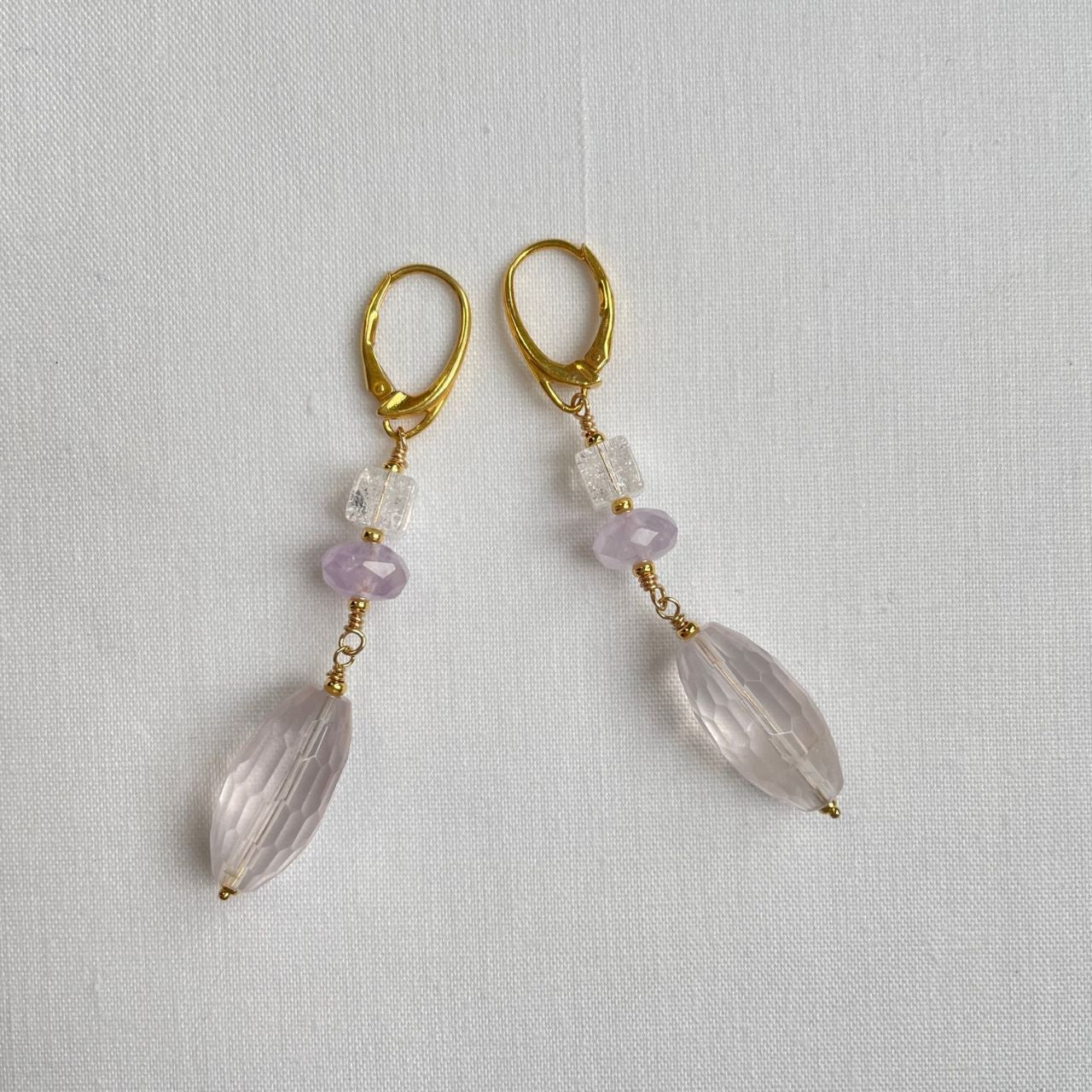 Oorbellen van een bergkristal cube, met een amethist rondel kraal en een rozenkwarts facetdruppel.