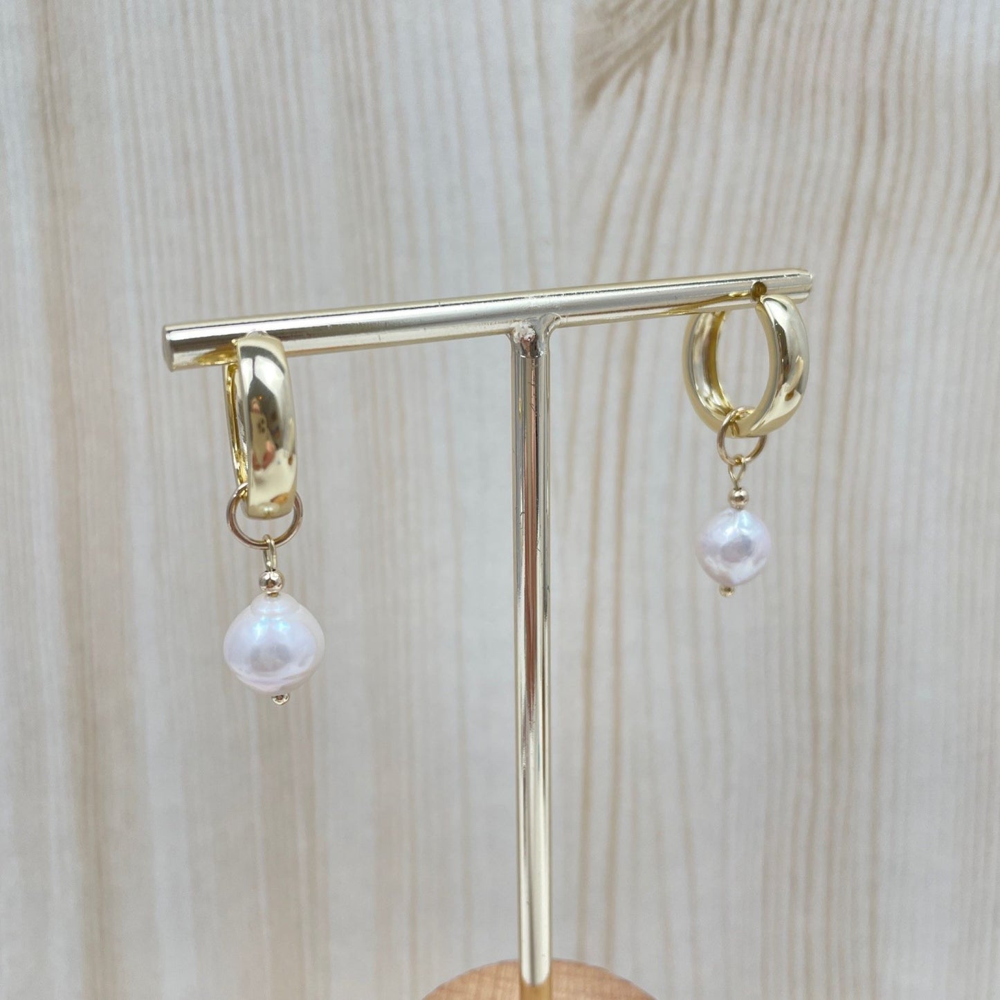 Gold filled huggies met daaraan een afneembare bedel van een grote zoetwaterparel hangend aan een standaardje