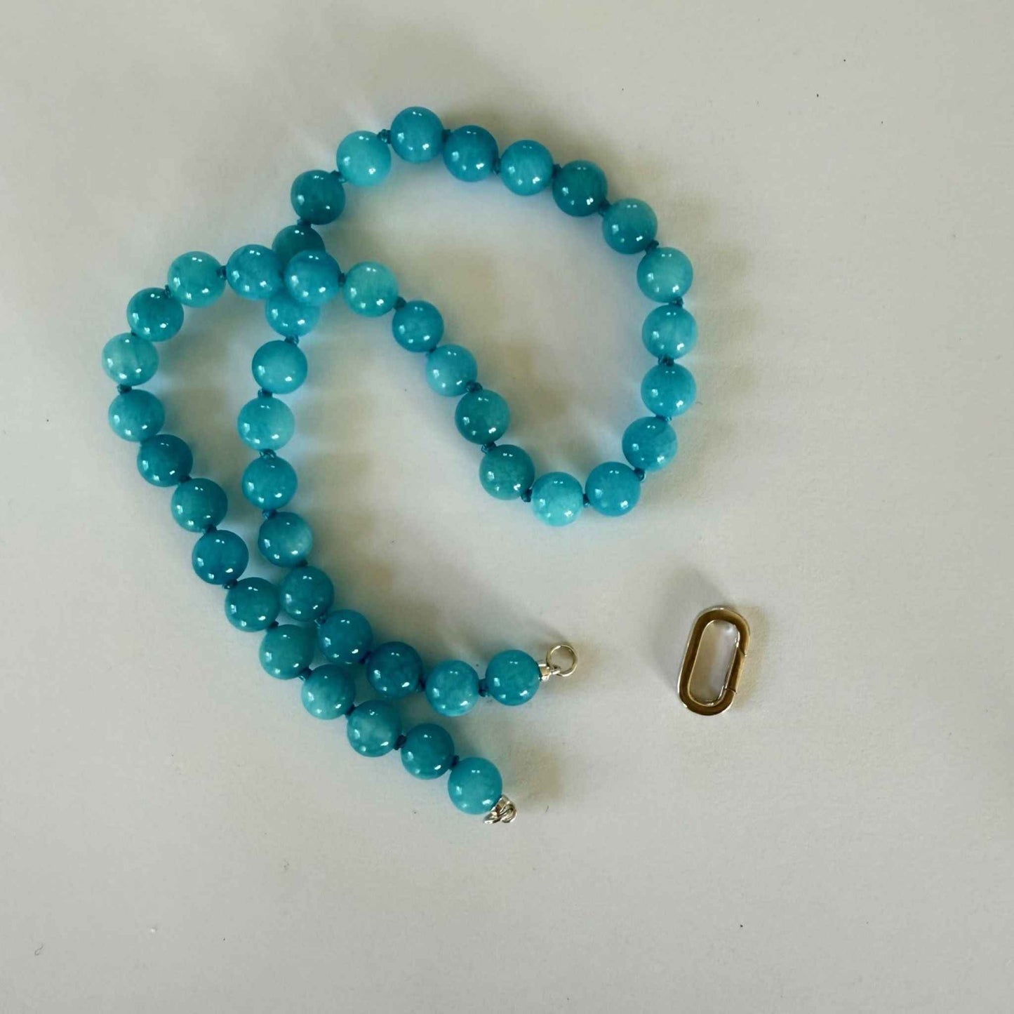 Ketting van helblauwe jade kralen met sterling zilveren open einden
