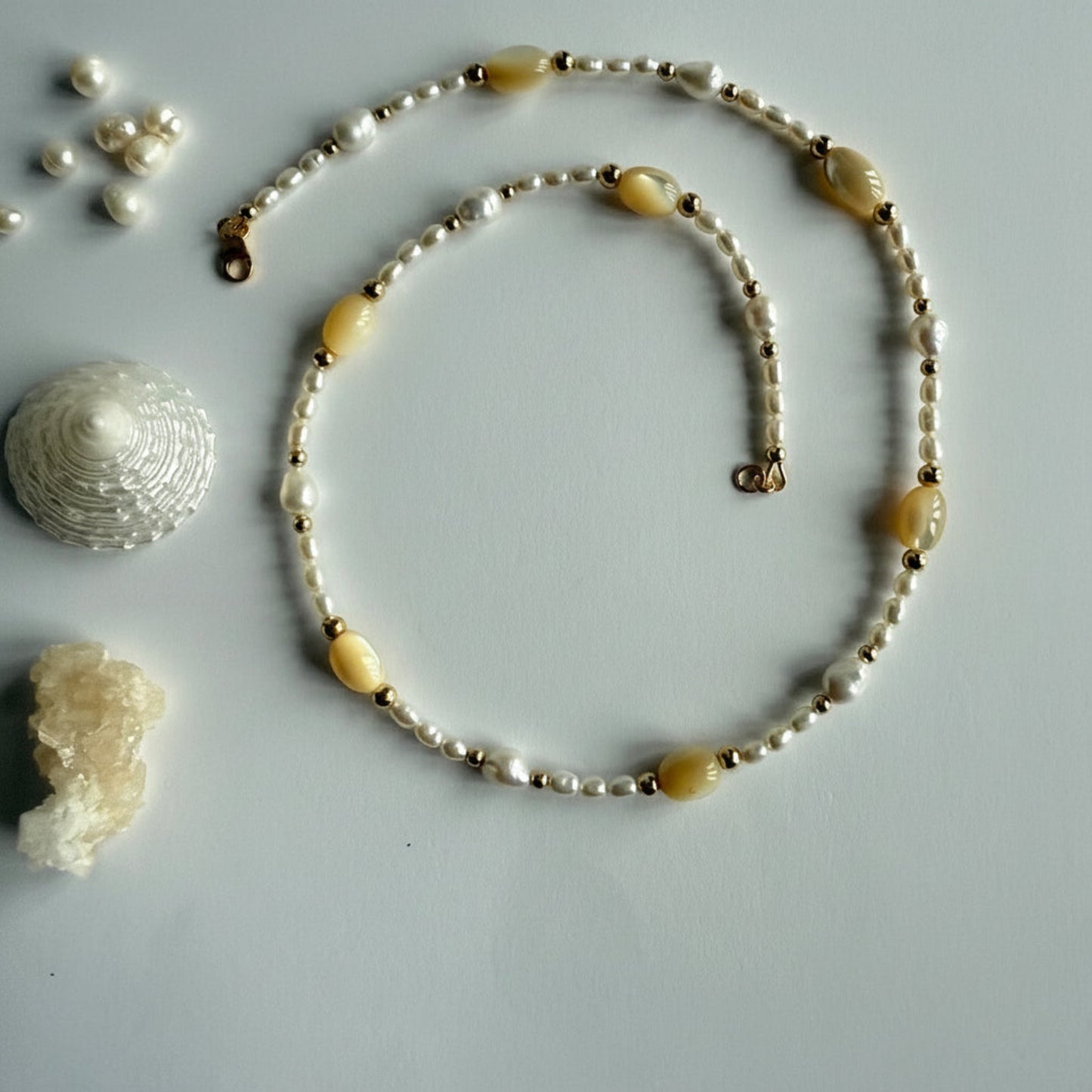 Korte ketting van goudparelmoer en zoetwaterparels met gold filled slotje