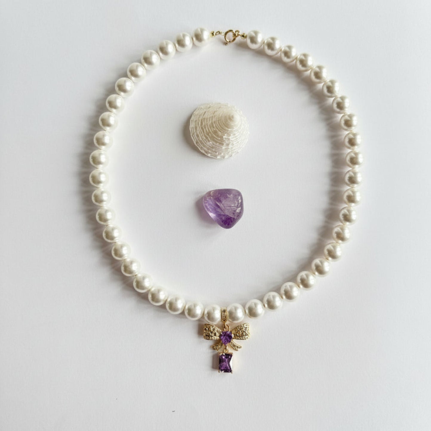 Ketting van schelpparels met paars strikje