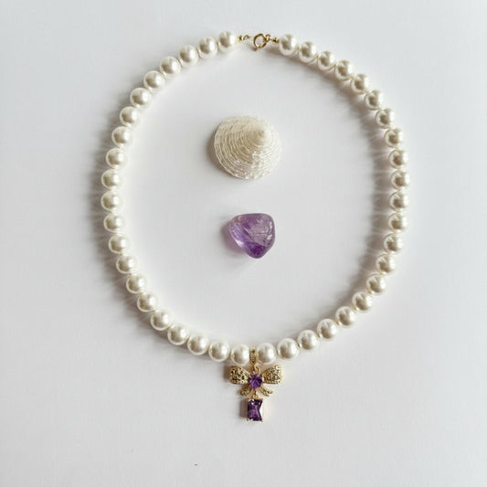 Ketting van schelpparels met paars strikje