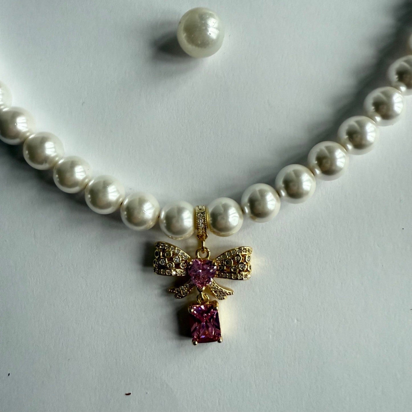 Ketting van schelpparels met roze strikje