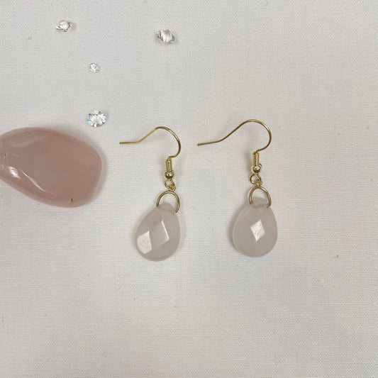 Aan een 14K gold filled haakje hangt een heel lichtroze platte facetdruppel van rozenkwarts. De facetjes op de druppel zorgen voor nog meer glans. De druppel hangt ook nog aan een gold filled boogje
