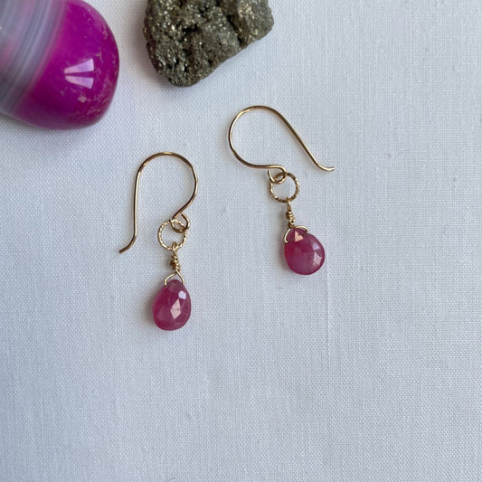 Aan een 14K gold filled haakje hangt aan een bewerkt ringetje een kleine roze saffier druppel. De druppel is facet geslepen, zodat de oorbellen nog meer licht vangen.