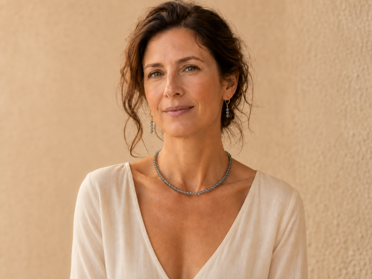 Vrouw draagt handgemaakte labradoriet ketting en oorbellen met gold filled huggie hoops — Engelina Jewelry