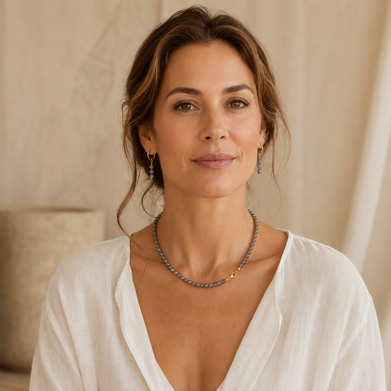 Vrouw draagt handgemaakte labradoriet sieradenset met ketting van ronde kralen en oorbellen met gold filled huggie hoops — Engelina Jewelry